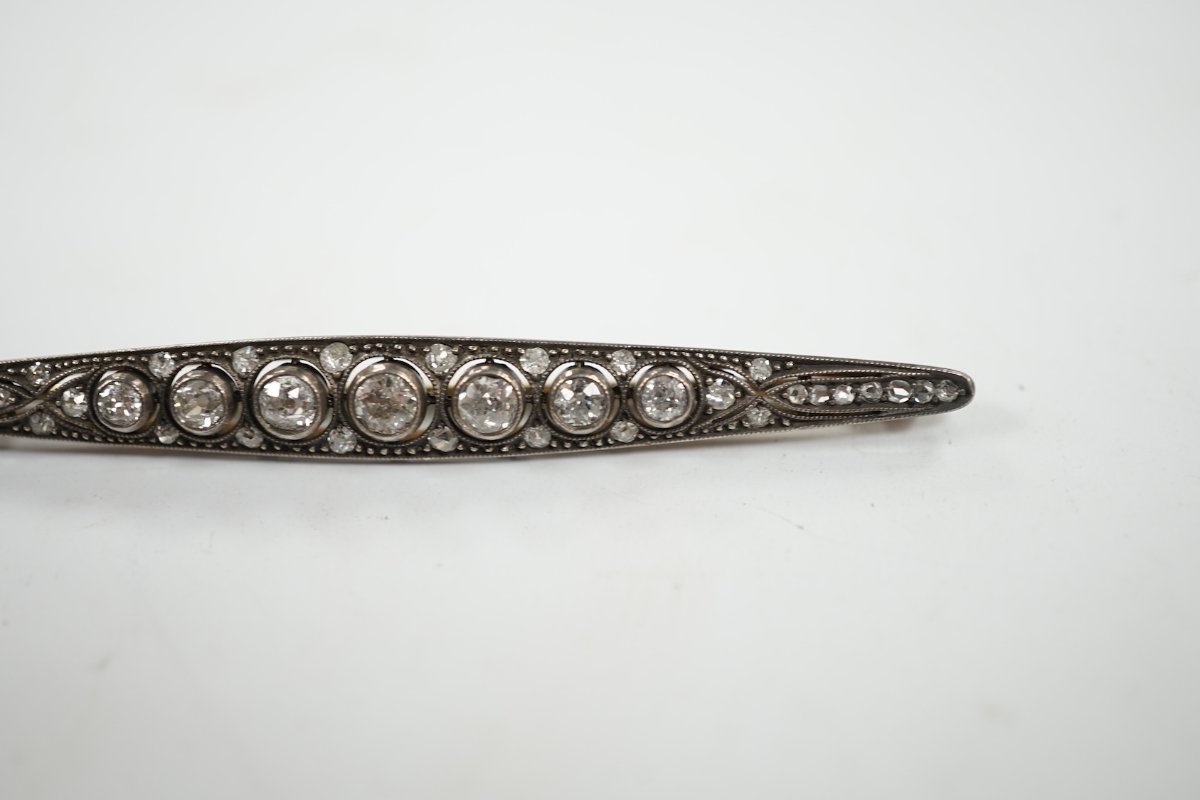 An Eastern European yellow metal (stamped 585) and white metal (stamped 875) and graduated diamond set bar brooch, 65mm, gross 5.1 grams. Condition - fair